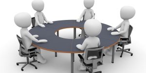 miniatur beberapa orang sedang meeting di sebuah meja